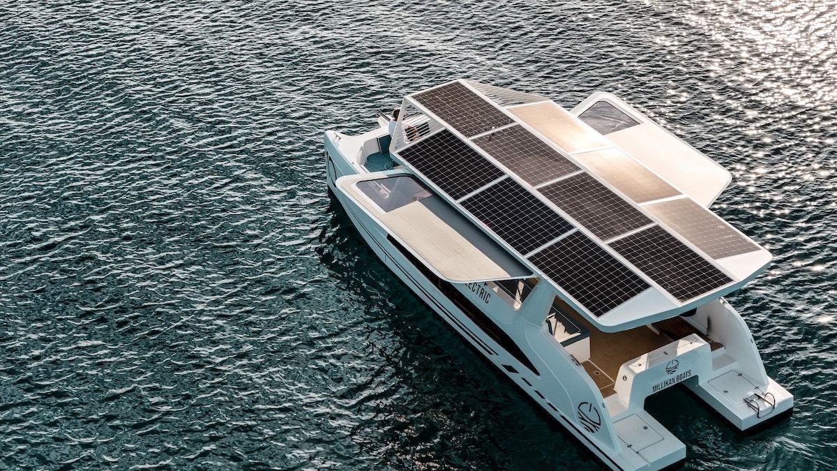 View of the back of the M10 catamaran from Millikan moving slowly in the ocean covered in solar panels